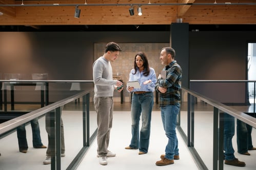 Colleagues standing together collaborating in a casual office setting