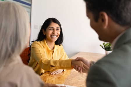 Smiling woman shaking hands with man