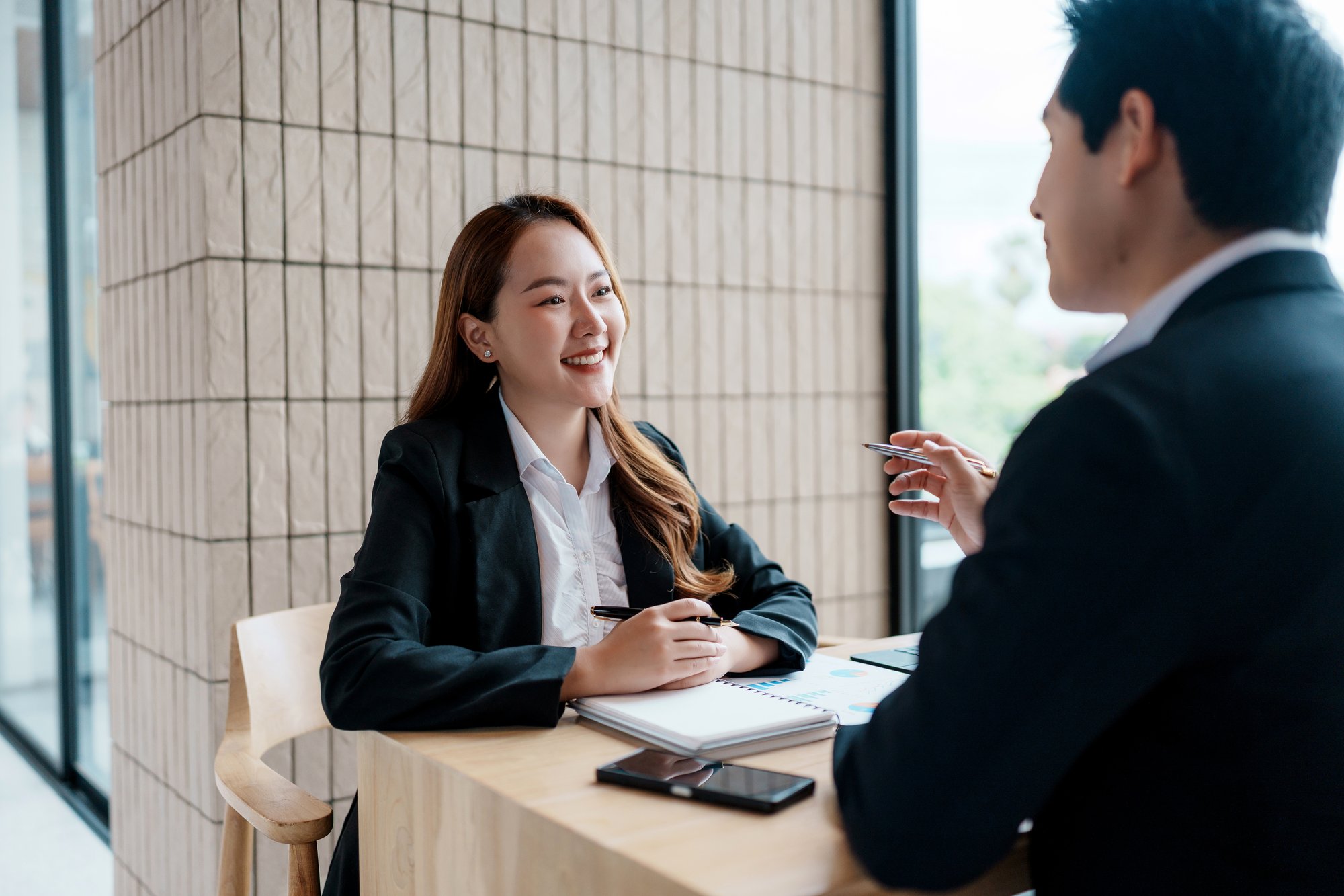 Two people in business attire sitting across from each other