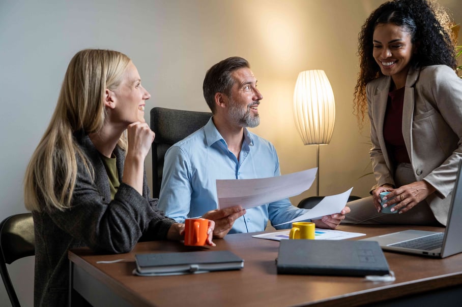 Three coworkers collaborating around one table in an office