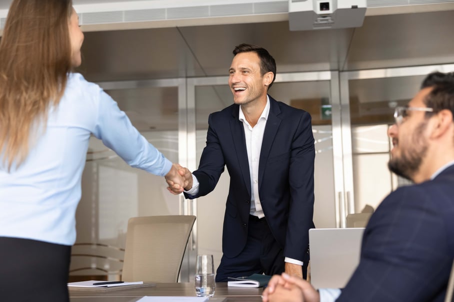 Man shaking hands with woman at table
