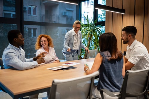 Group of laughing coworkers getting ready for a meeting