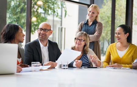 Small group of smiling people working together at a table