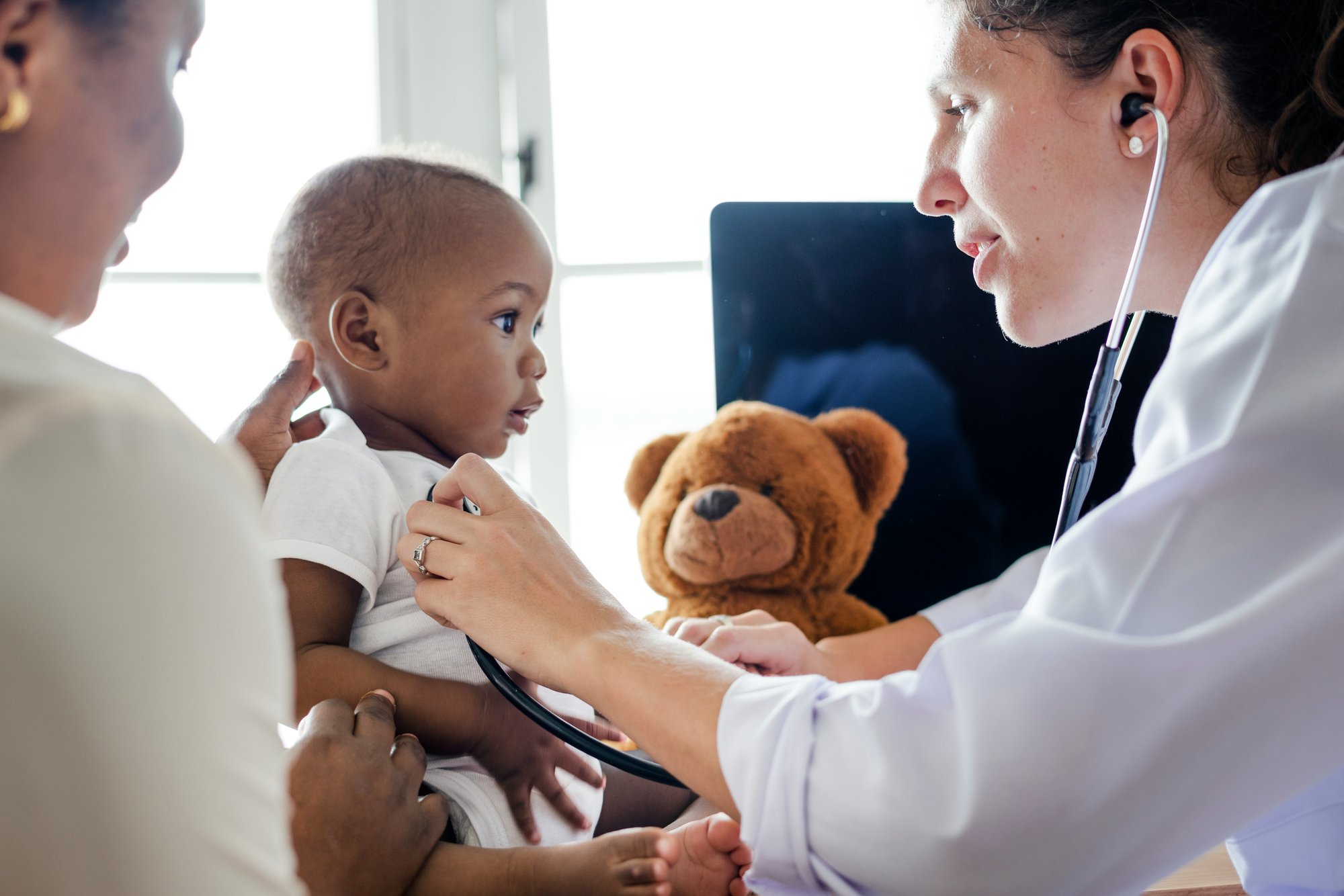 Pediatrician checking baby's heart