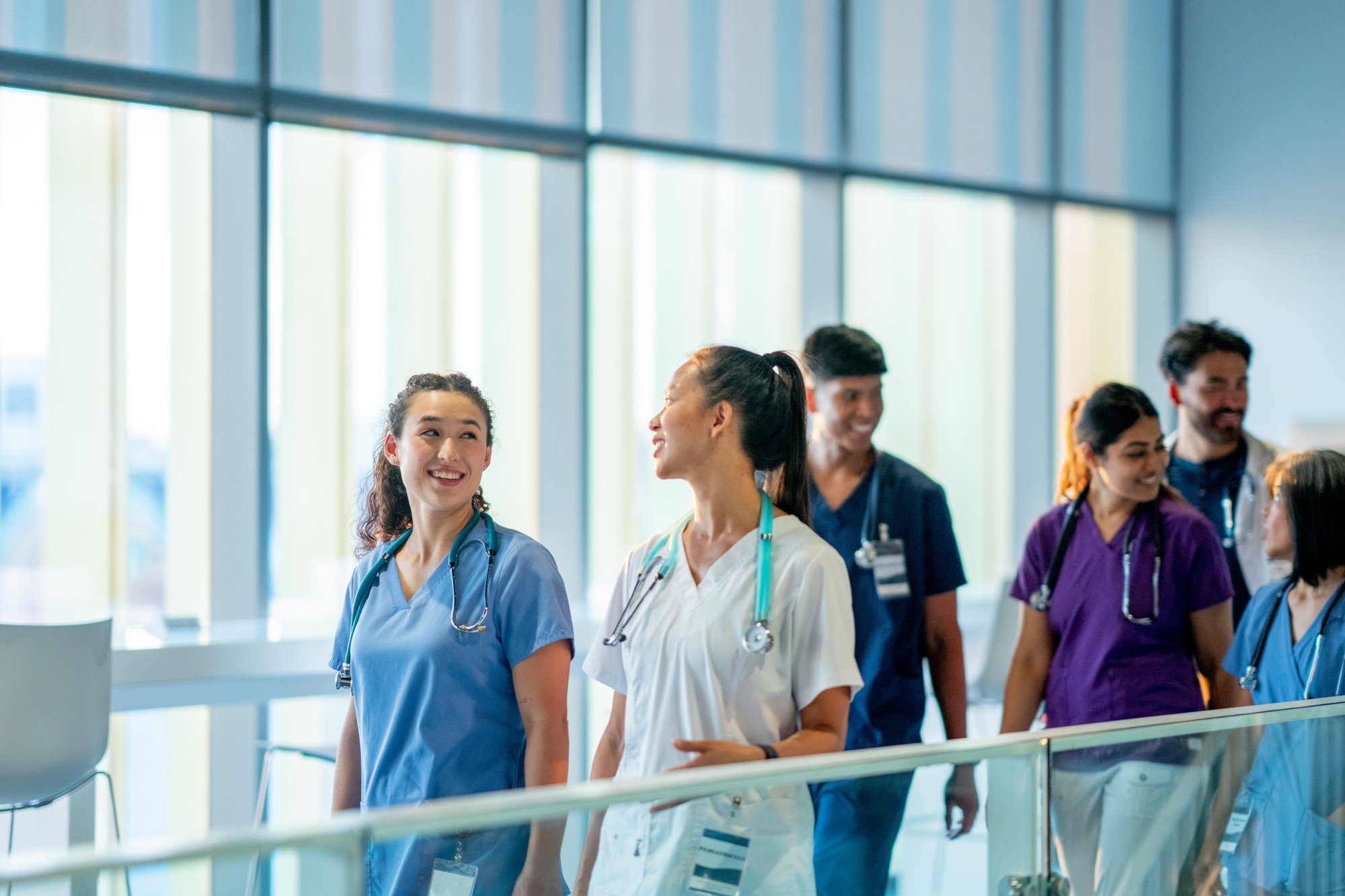 Happy healthcare workers walking together through building