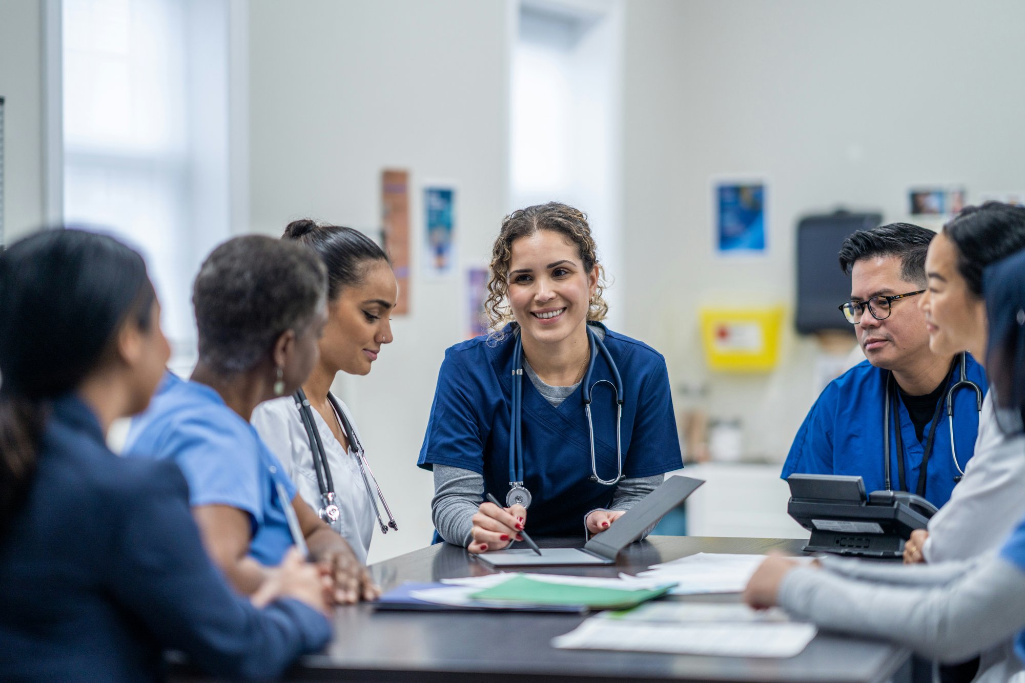 Group of healthcare workers sitting around a table at work