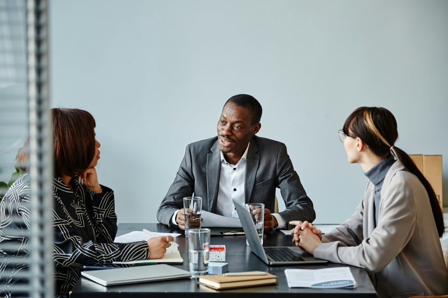 Three coworkers talking around a table
