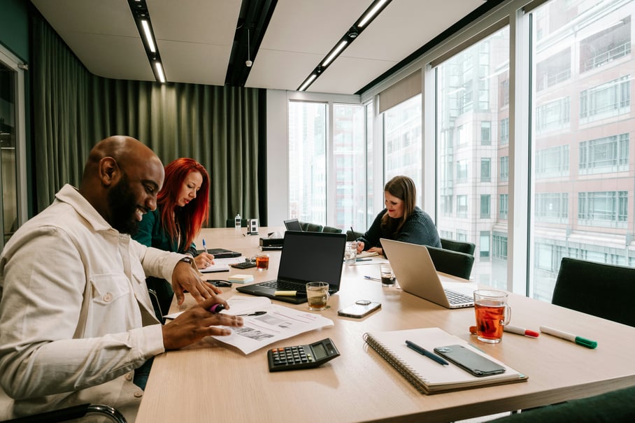 Three colleagues happily coworking at a large table